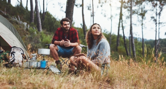 Young man and woman camping in nature