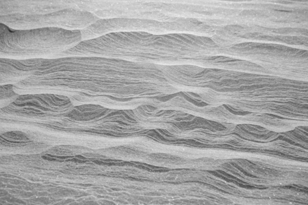 Rippled lines forming pattern on icy snow landscape