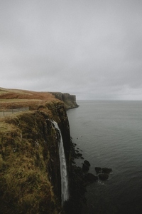 Waterfall over rugged ocean cliff