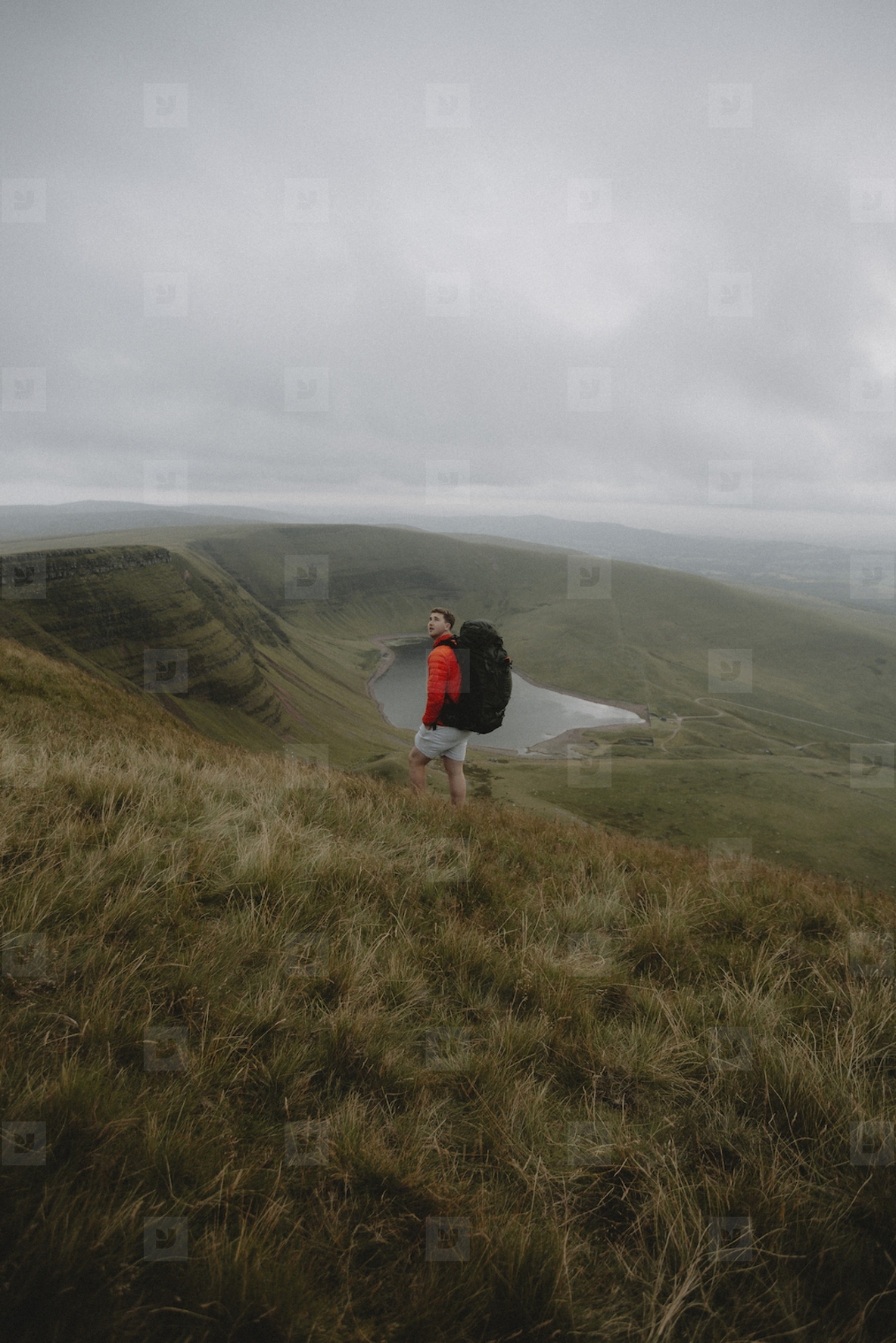 Man with backpack hiking on grassy