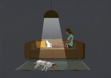 Dog sleeping on floor next to woman working late at laptop on sofa