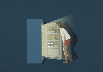 Woman standing at open refrigerator in kitchen at night