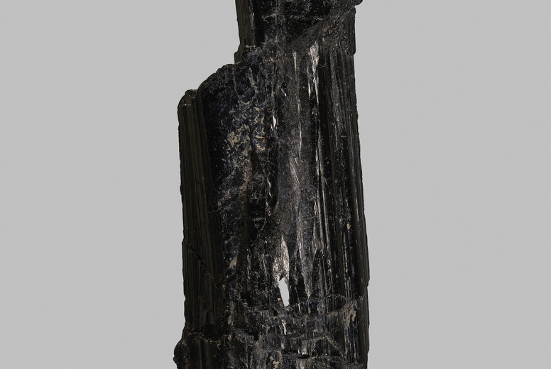 Close up black schorl stone on gray background