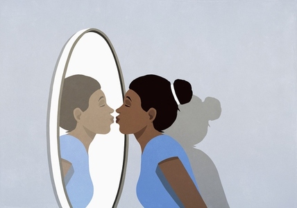 Woman kissing reflection in mirror