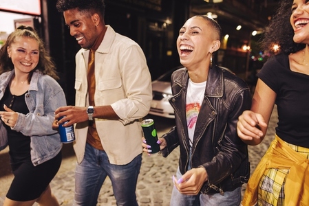 Four friends laughing happily in the city at night