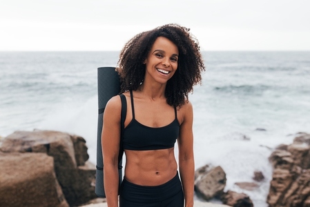 Portrait of a laughing woman with curly hair wearing fitness clo