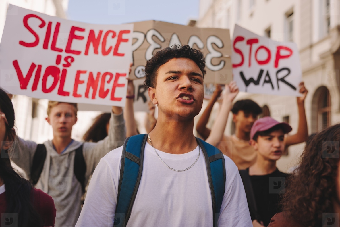 Teenage boy marching against war with a group of protestors