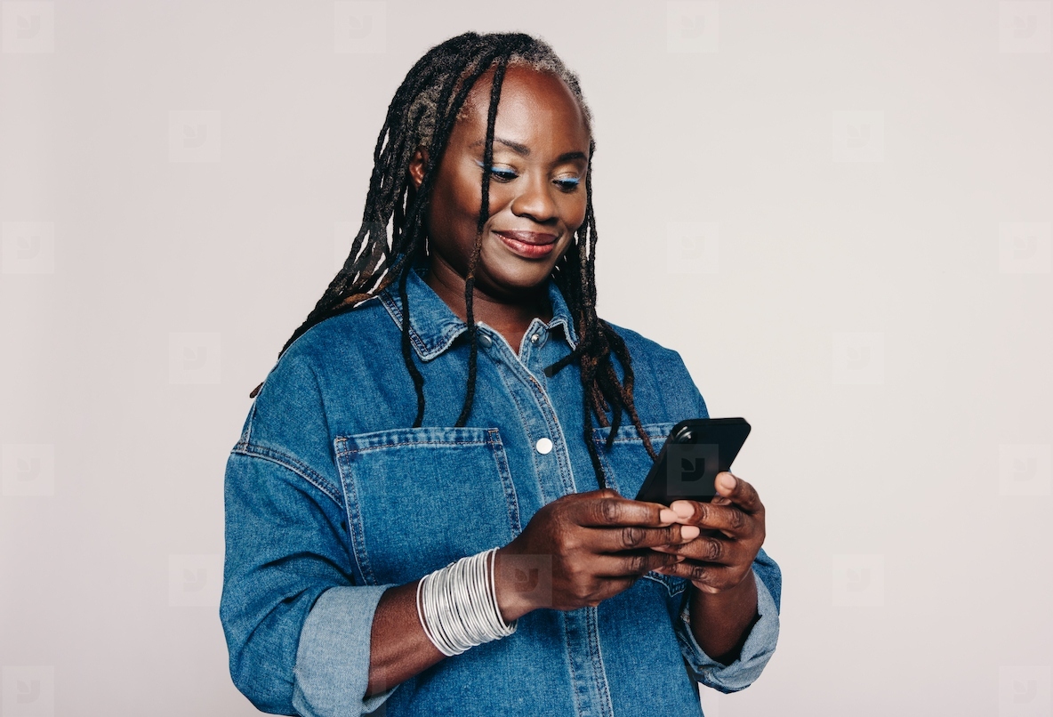 Woman with dreadlocks using a smartphone in a studio