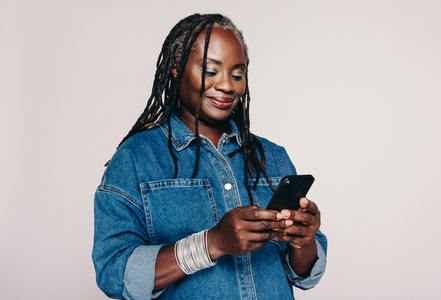 Woman with dreadlocks using a smartphone in a studio