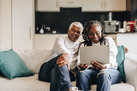 Happy mature couple having a video call on a digital tablet