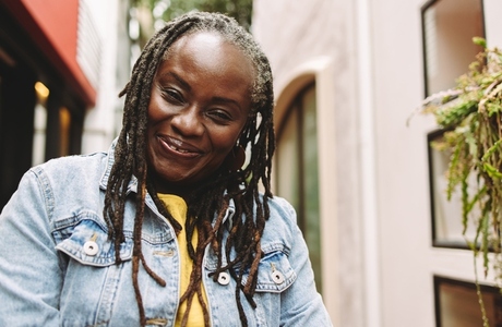 Woman with dreadlocks smiling at the camera happily