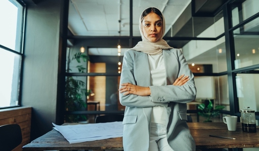 Confident Muslim woman standing in a modern office