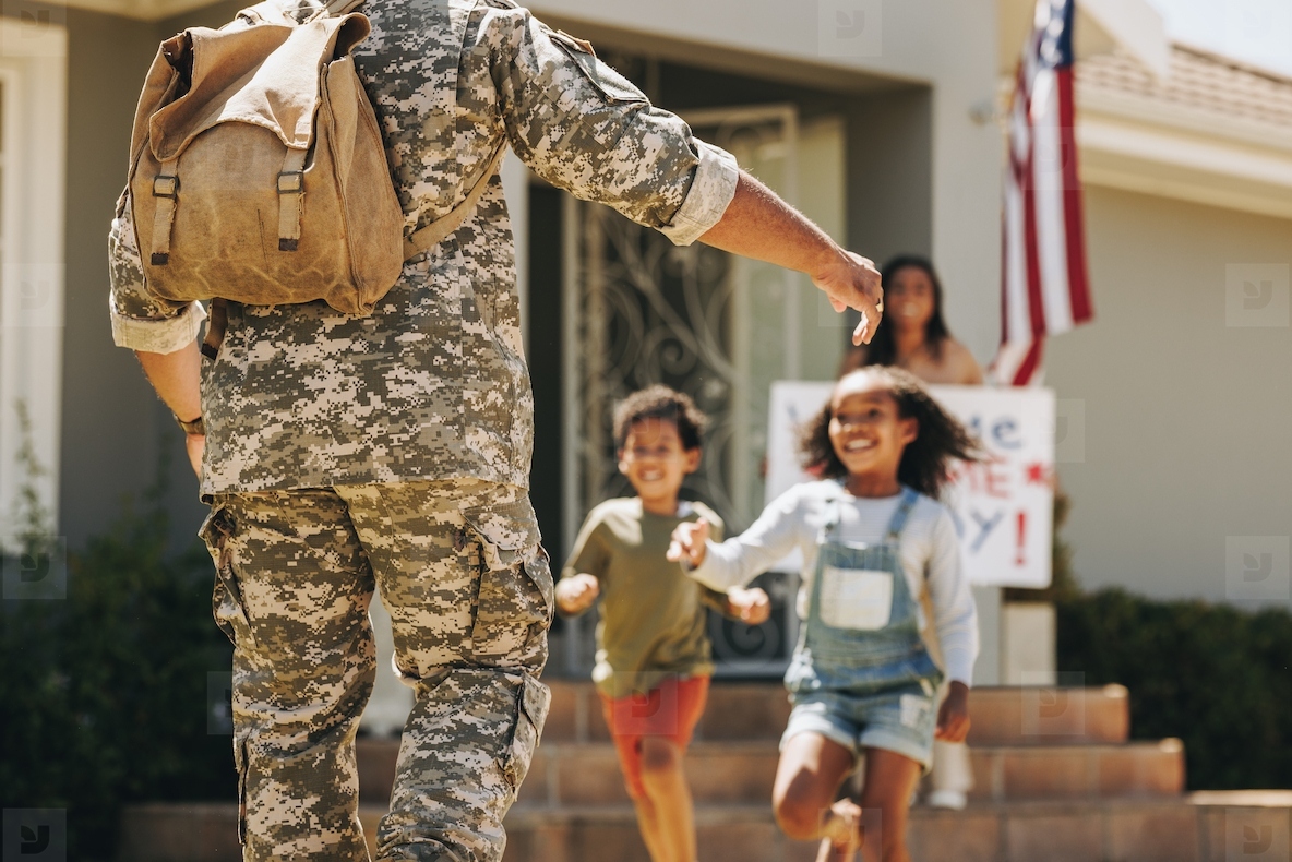 Excited children running to embrace their military father