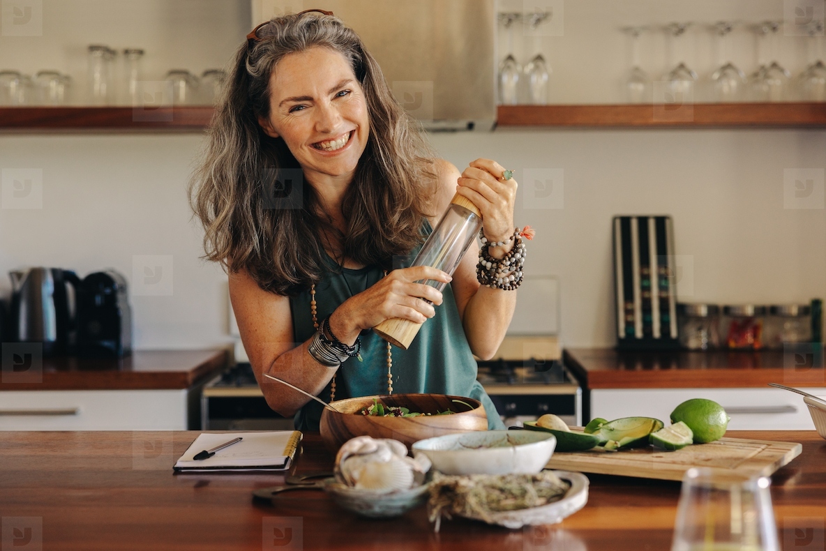 Cheerful senior woman following a healthy vegan recipe at home