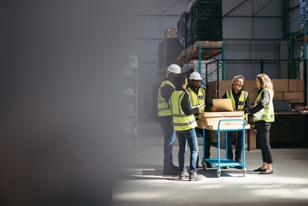 Group of happy warehouse employees having a meeting together