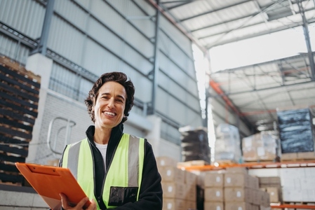 Mature logistics manager smiling at the camera in a warehouse