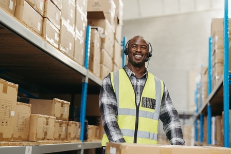 Happy warehouse picker smiling at the camera with a headset on