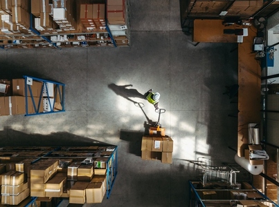 Aerial view of a warehouse employee puling a pallet truck
