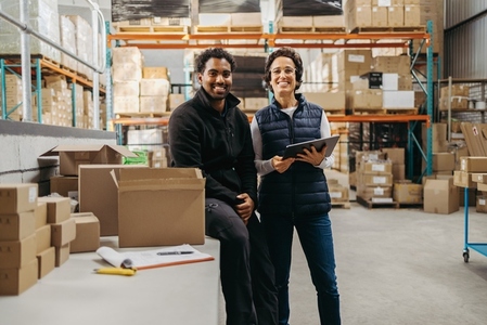 Successful warehouse workers smiling at the camera