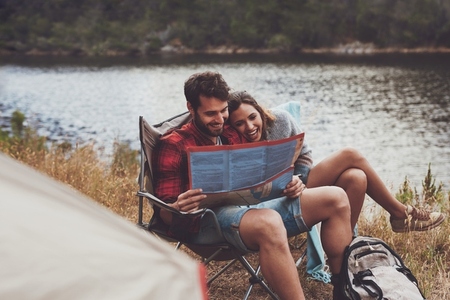 Adventurous couple looking at a travel map