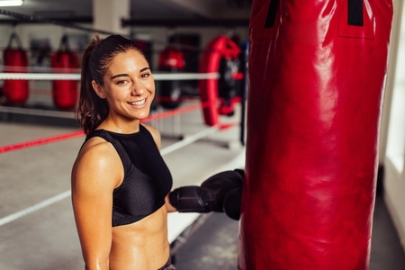 Happy female boxer smiling at the camera in a gym