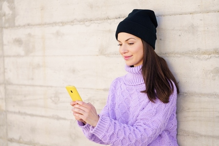 Female student in her twenties using smartphone outdoors
