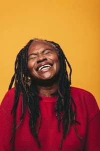 Happy black woman laughing cheerfully in a studio
