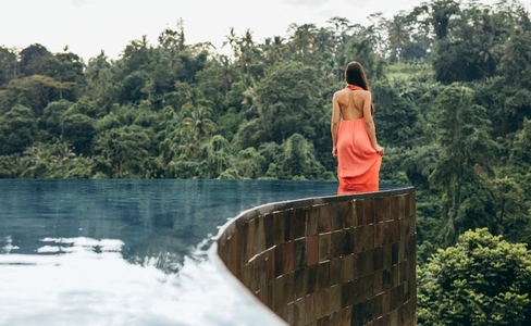 Young woman in infinity pool at luxury resort