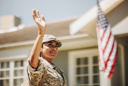 Patriotic female soldier waving her hand on her homecoming