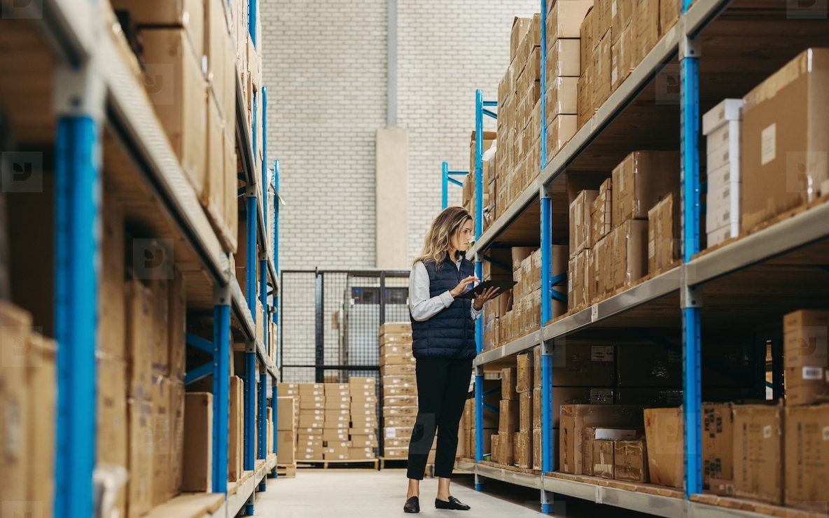 Female warehouse worker doing inventory control using warehouse management software
