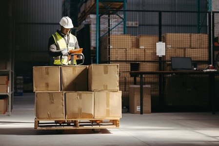 Warehouse employee reading a clipboard in a logistics centre