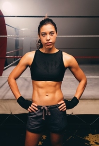 Confident female boxer looking at the camera in a gym