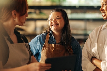 Retail worker with Down syndrome smiling during a staff meeting