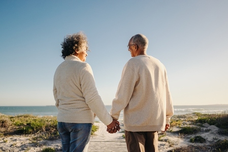 Rearview of a senior couple holding hands at the beach