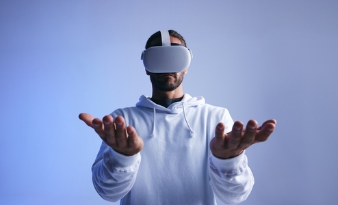 Young man holding his hands out in virtual reality