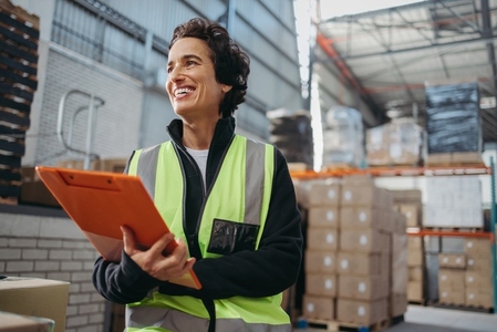 Happy warehouse manager smiling while holding a file