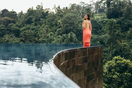 Attractive woman in infinity pool of holiday resort