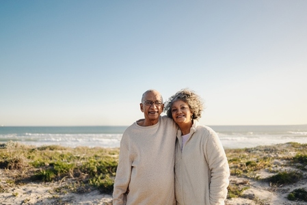 Portrait of a senior couple smiling at the camera at the beach