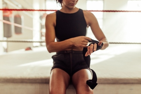 Female athlete sitting on the edge of a boxing ring