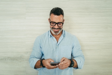 Mature businessman reading a text message on his smartphone