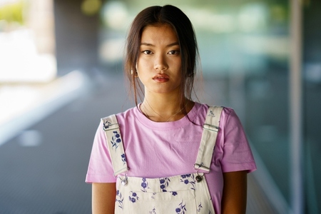 Young Chinese woman looking at camera with serious expression in a modern office building
