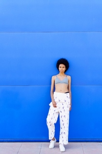 Black woman in bra near blue wall