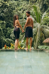 Love couple standing on the edge of the pool