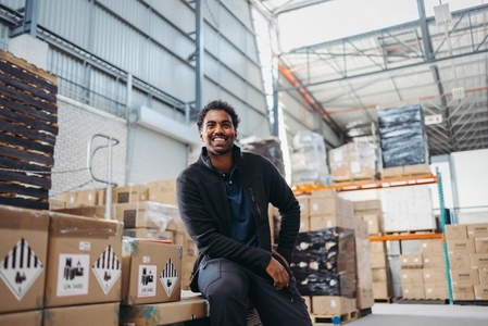 Logistics worker smiling happily in a distribution warehouse