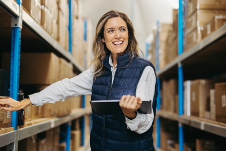 Cheerful warehouse manager working with a digital tablet