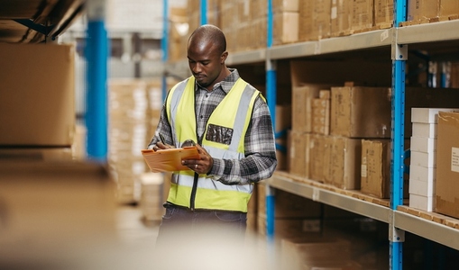 Young logistics manager doing inventory control in a warehouse
