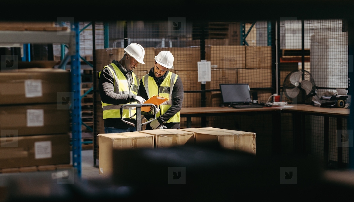 Warehouse employees reading a clipboard in a logistics centre