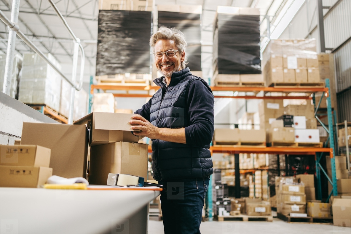 Cheerful senior man smiling while working in a warehouse