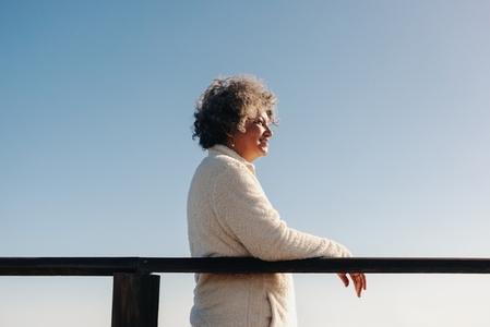 Mature woman getting a view of the ocean from a bridge