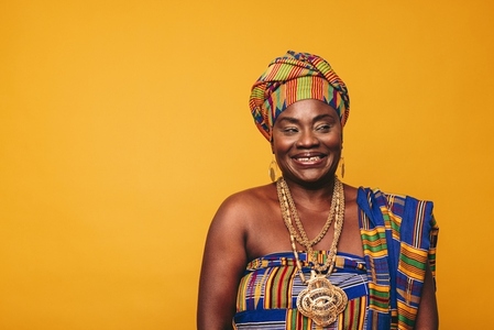 Smiling African woman wearing elegant traditional clothing in a studio
